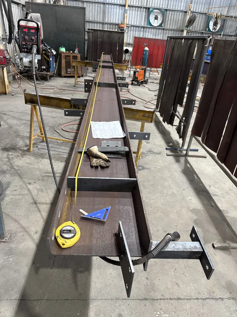 Long steel beam being fabricated on the workshop floor
