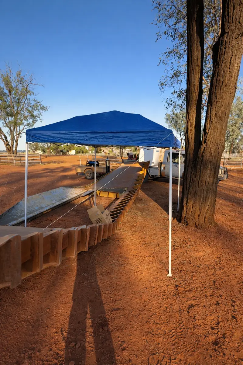 Mobile repair setup under a gazebo on red dirt